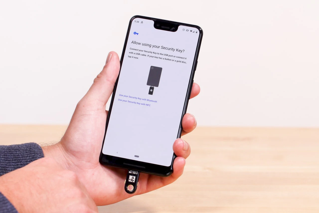 Hardware security key connected to a smartphone during account authentication